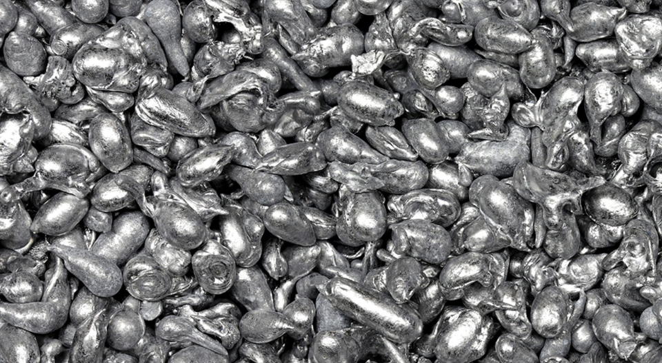 Close-up of a crowded pile of shiny silver-coated candies (dragees) used for decorating desserts in baking.